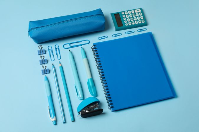 Flat lay with different school supplies on blue background