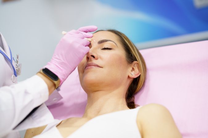 Woman having face prepared for treatment in medical salon