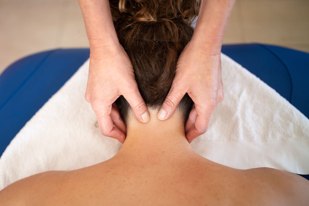 Hands of osteopath working on client's neck