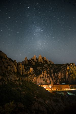 Starry night sky over quaint mountain town