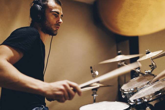 Man with headphones playing on drums