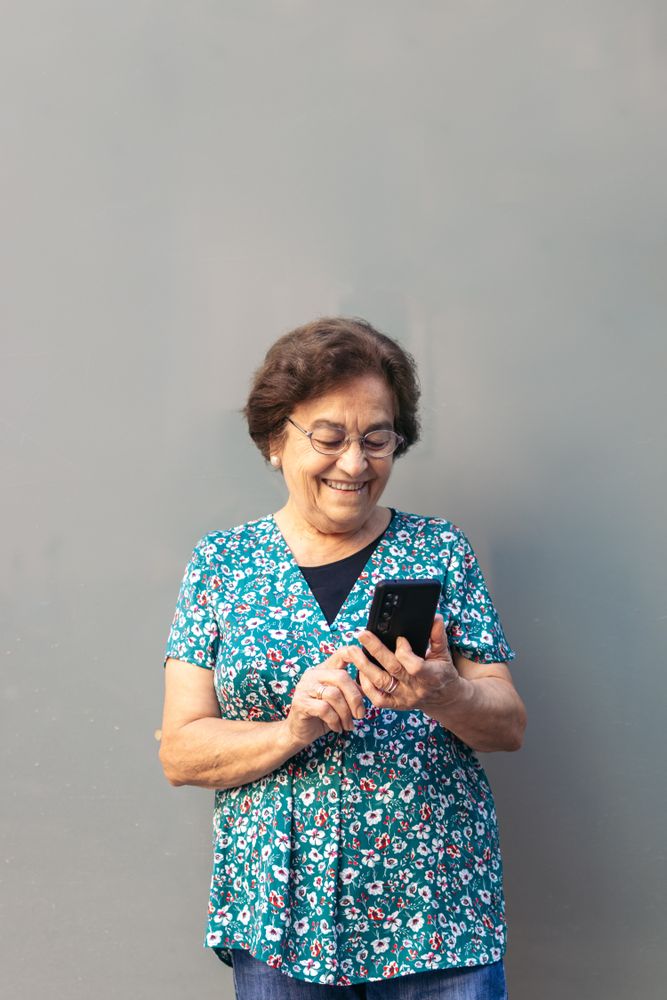 Smiling older woman using smartphone outdoors