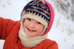 Happy child bundled up and playing in snow