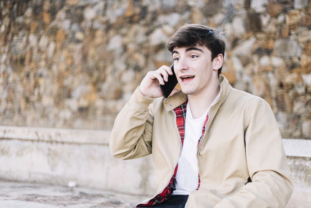 Man sitting outdoors talking on cell phone