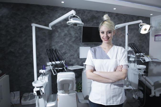 Smiling dentist with her arms crossed at work