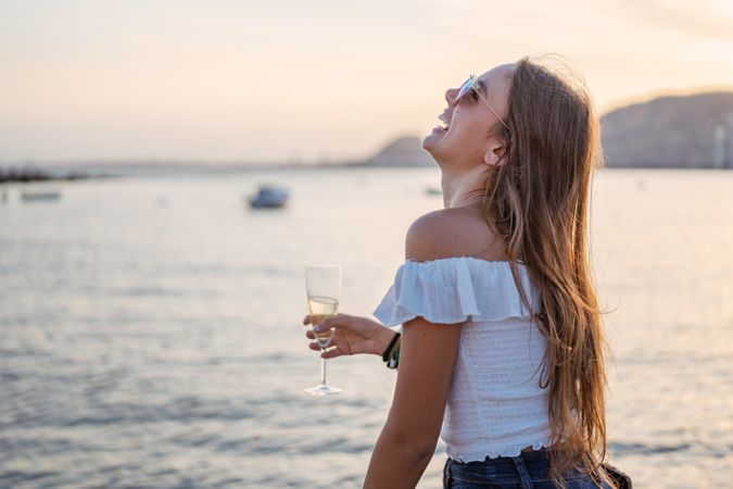 Young woman enjoying wine near sea
