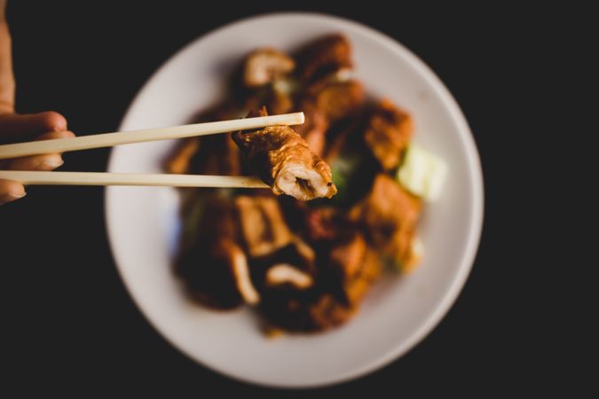Hand eating prepared delicious pork belly with vegetables