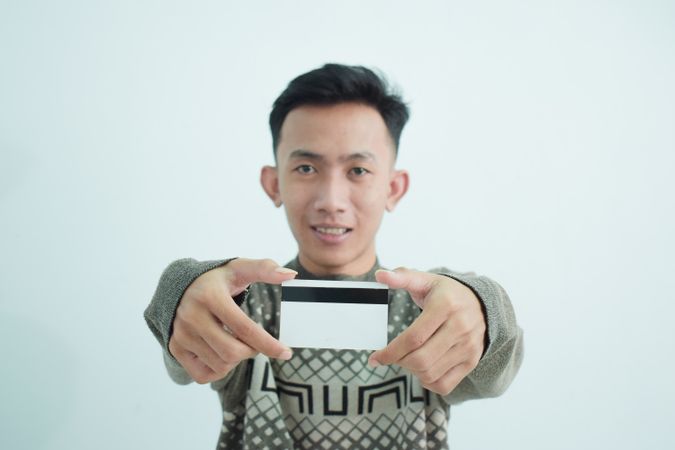 Asian young men wears sweater and holding blank credit card