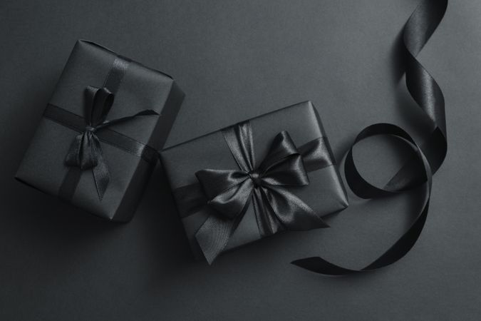 Gift boxes with dark bows on dark background