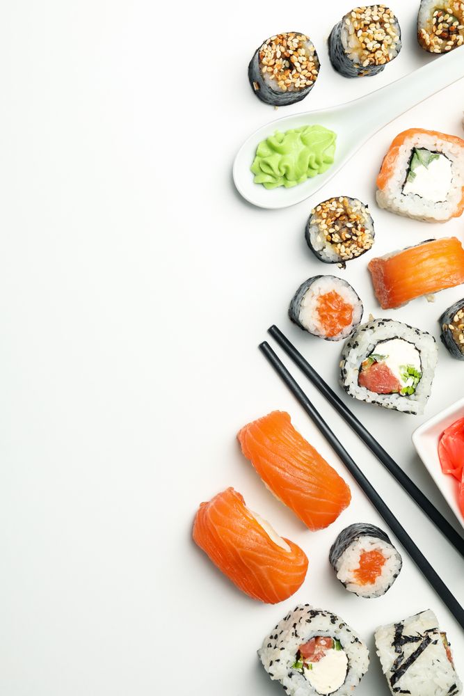 Sushi rolls and chopsticks on light background, space for text. Japanese food