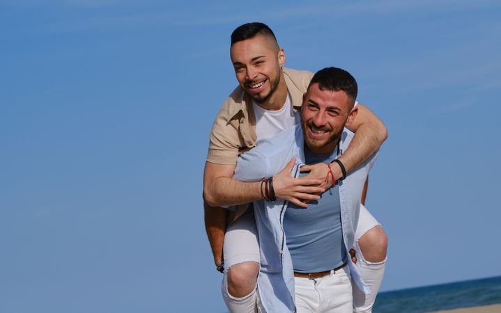 Happy gay couple playing piggyback
