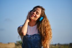 Carefree woman listening to music in headphones in nature