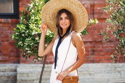 Woman walking next to brick building in summer dress