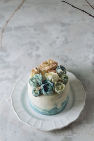 Buttercream flowers cake, blue and pastel peach colors
