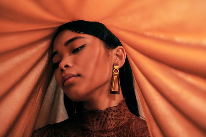 Woman’s head draped in orange fabric