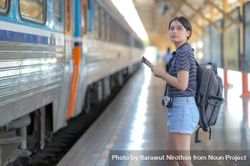 A female traveler with a rucksack waiting for a train 0yD6jb