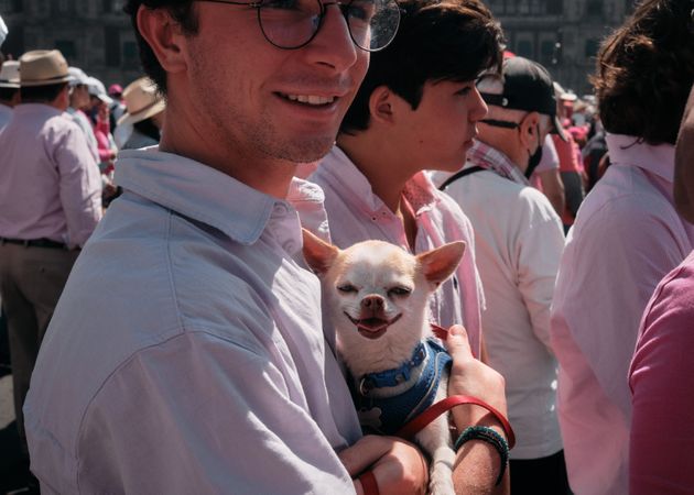Mexico City, Mexico - February 26th, 2022: Man holding adorable chihuahua at protest in Mexico City