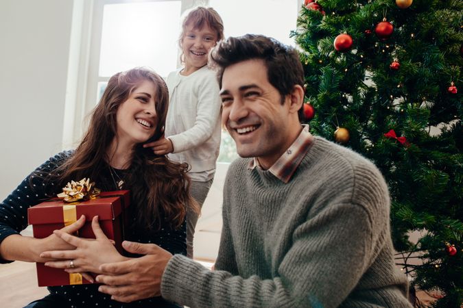 Family celebrating Christmas at home in front of tree