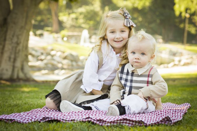 Sweet Little Girl with Her Baby Brother at the Park.