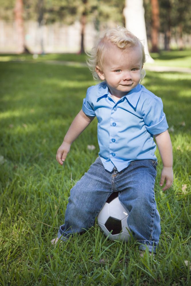 Young Cute Boy Playing with Soccer Ball in Park
