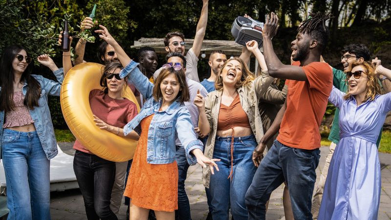 Many multi-ethnic people having fun dancing outside in the garden