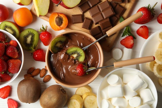 Composition with ingredients for chocolate fondue on wooden background. Cooking fondue
