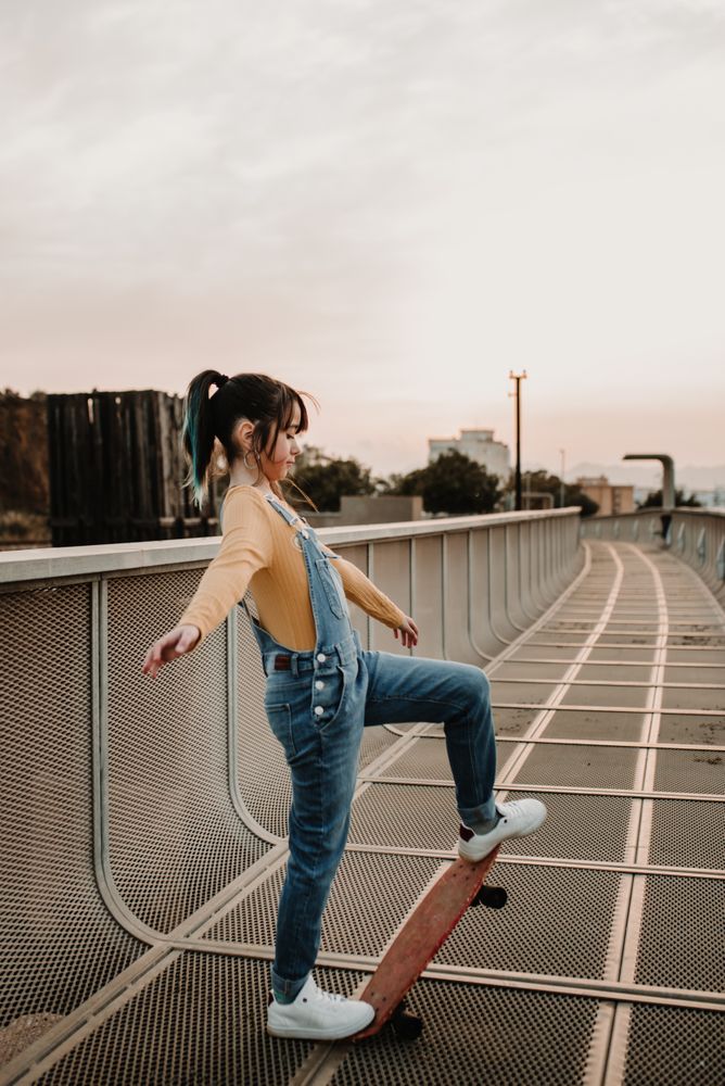 Girl with skateboard on walkway