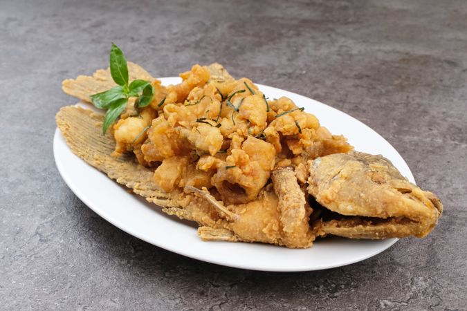 Gurame Saos Telur Asin. Crispy fried gourami fish covered with salted egg sauce. Indonesian food