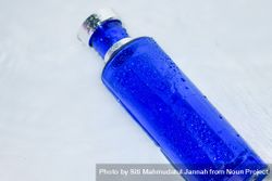 Blue perfume bottle with water droplets on light background 5lVmlm
