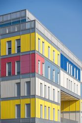 Facade of modern multicolored building with narrow windows