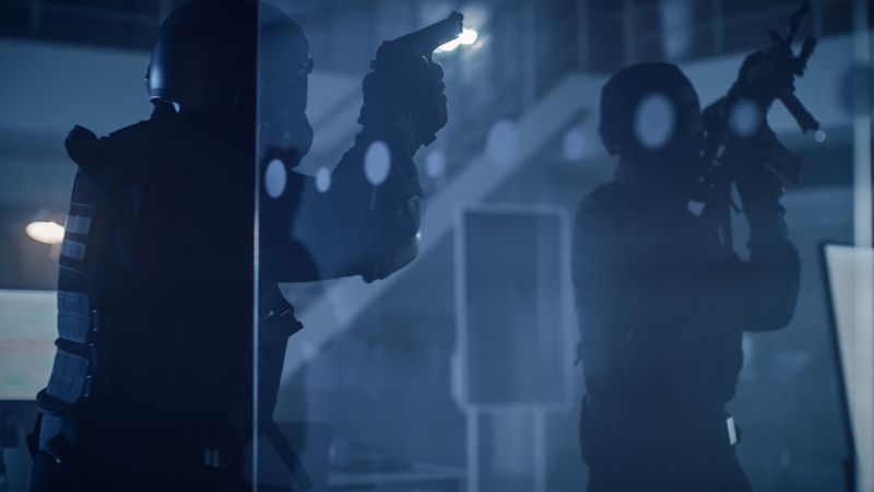 Masked Team of Armed SWAT Police Officers Move in a Hall of a Dark Seized Office Building.