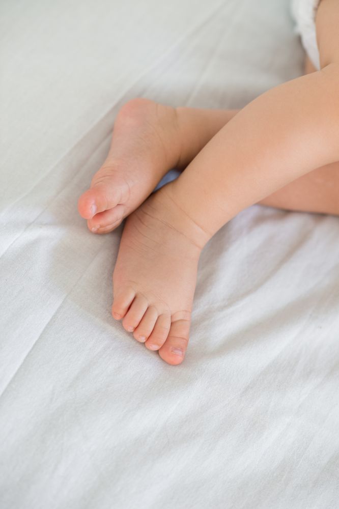 Lovely feet of a baby sleeping in your bed