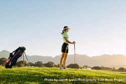 Female golfer holding golf club on field 4NqBm5
