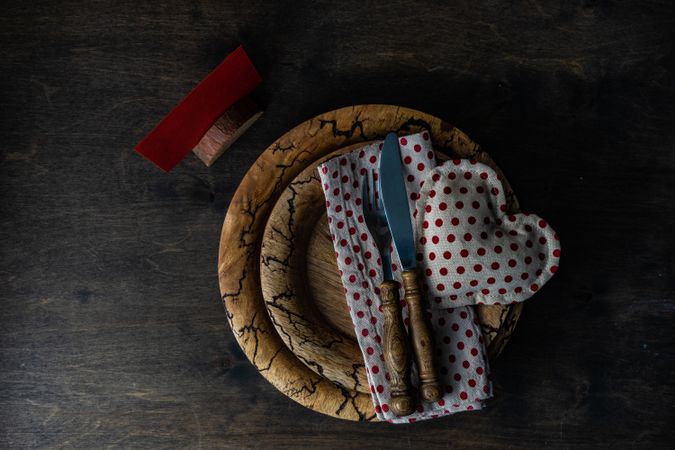 Valentine's day table setting with red dotted napkin and heart decoration on rustic plate