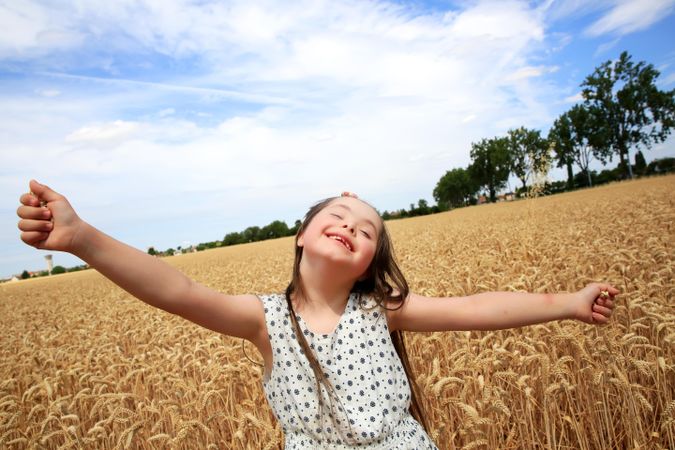 Joyful young girl playing in a field on a nice day