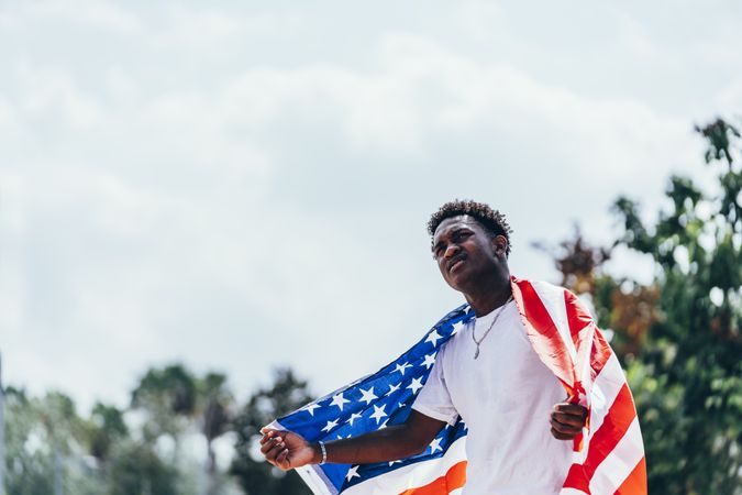 Black man in American Flag outside