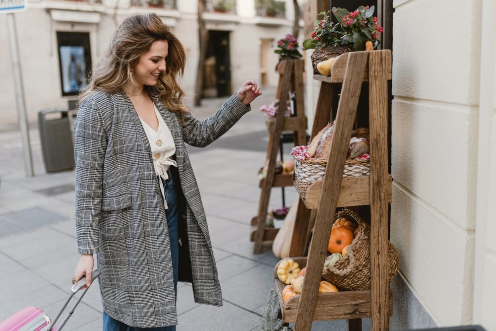 Smiling female tourist near grocery shop