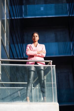 Proud woman in smart business attire standing tall outside building looking at camera