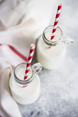 Bottle of milk with striped straws on kitchen counter