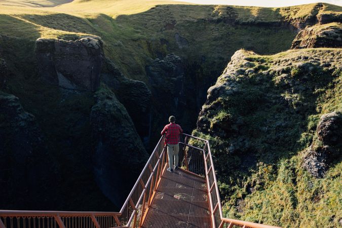 Man on walkway over cliffs