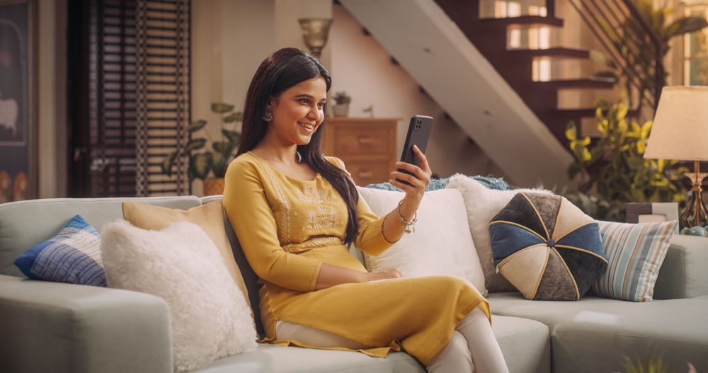 Young Indian Woman Making a Video Call on Her Smartphone at Home, Sharing Laughs and Gossip