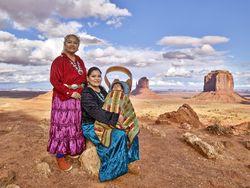 Three generations of Navajo family members posing in Monument Valley, AZ A0yPjb