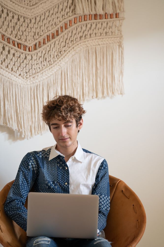 Person sitting in leather chair with laptop