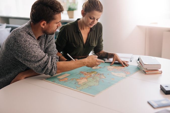 Man and woman planning trip with world map