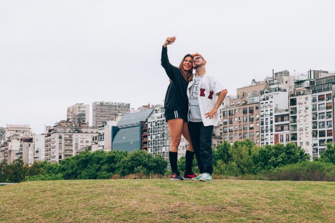 Friends smiling while making selfie on smartphone at city