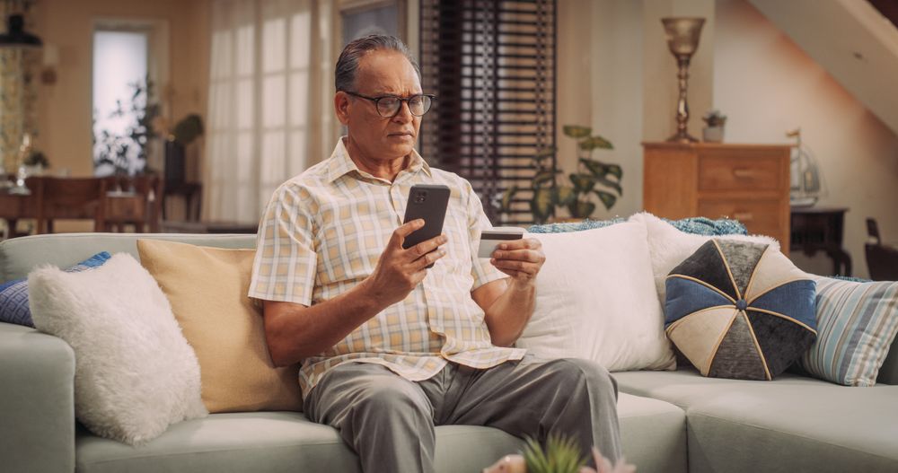 Indian Man Using Smartphone and Credit Card: Effortlessly Navigating Online Shopping, Making Secure Transactions