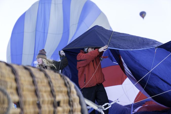 Hudson, WI, USA - February 8th, 2020: Two people under the fabric of a hot air balloon