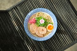 Delicious ramen soup with soft egg and pork meat in bowl