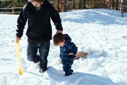 Man with kid walking in snowy yard
