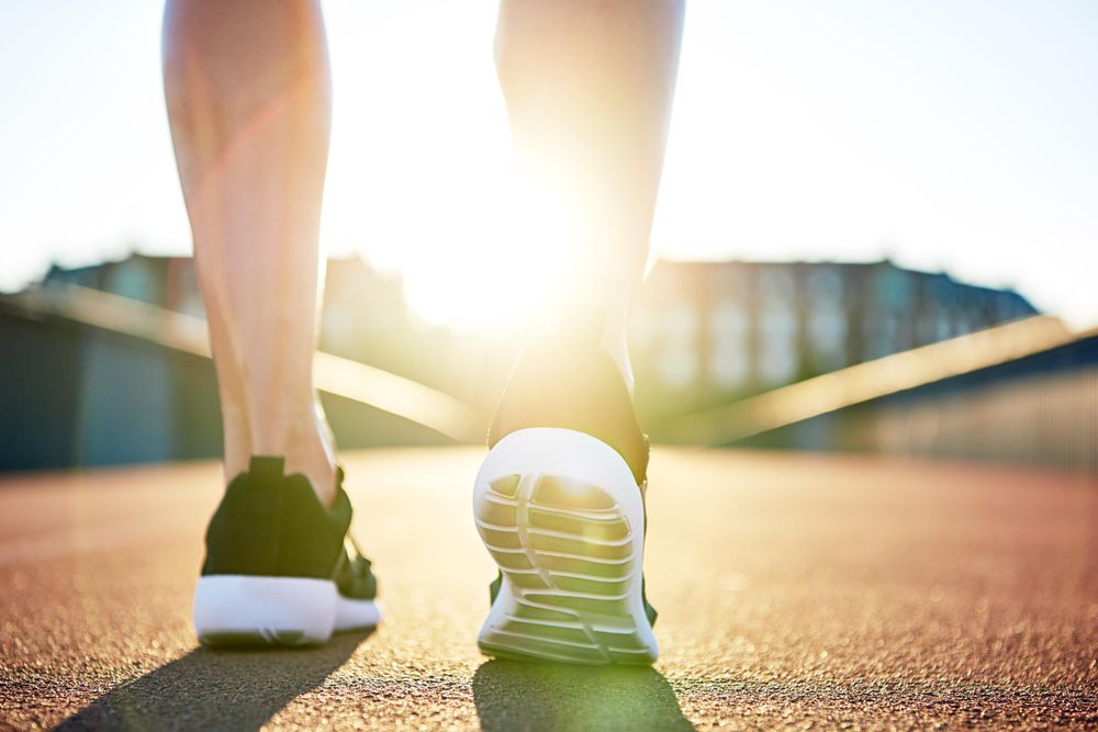 Close up of woman’s running shoes on sunny bridge